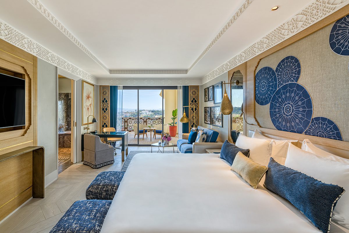 A bedroom with a large window and blue, white and gold details