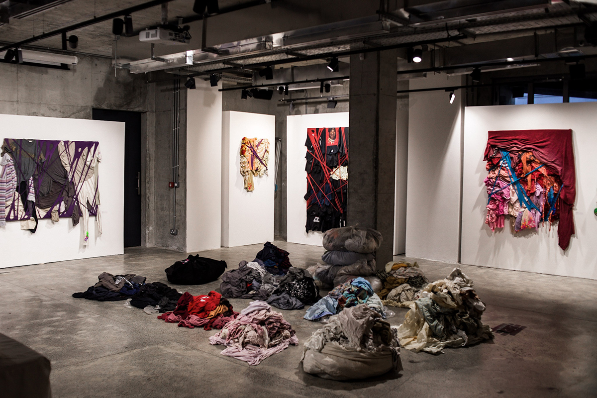 clothes on the floor next to tapestries hanging on the walls
