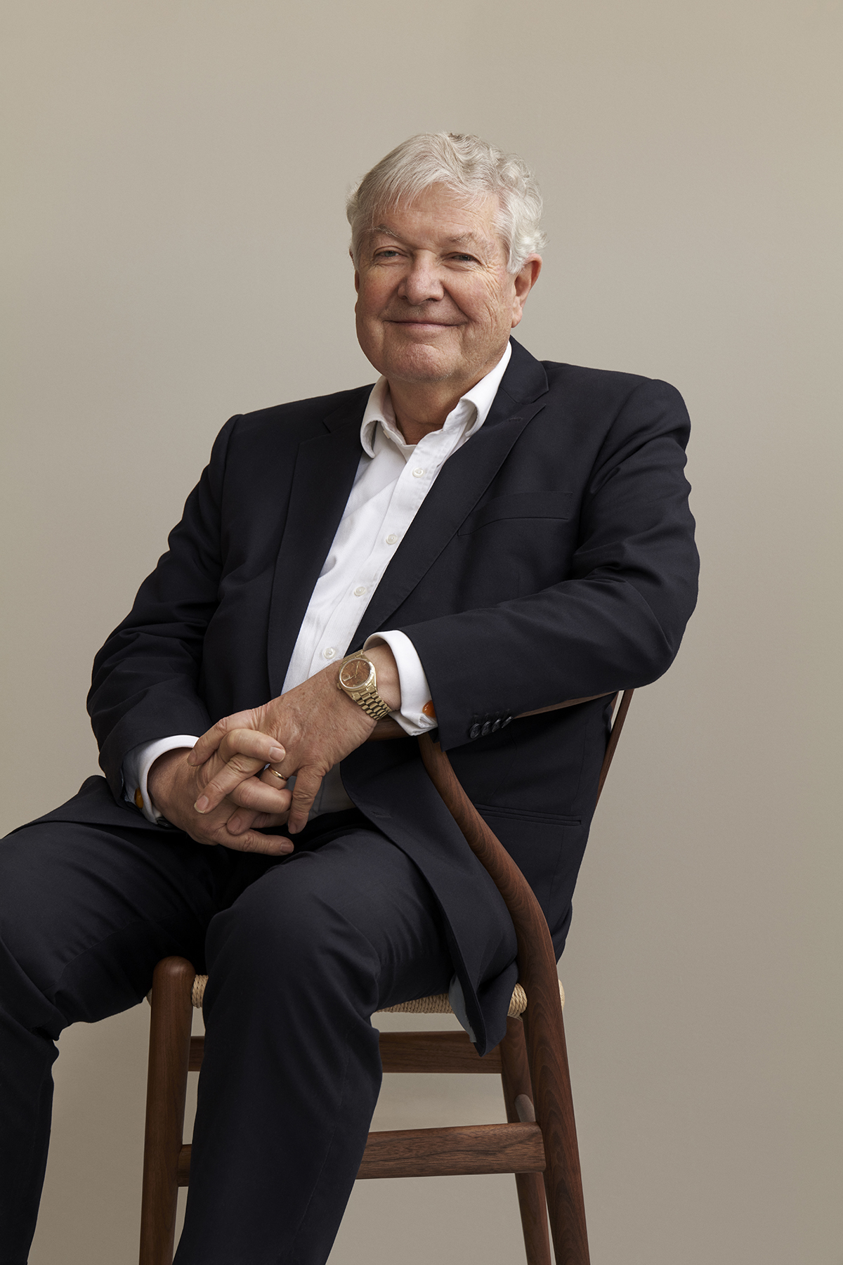 Man in a suit sitting on a wooden chair