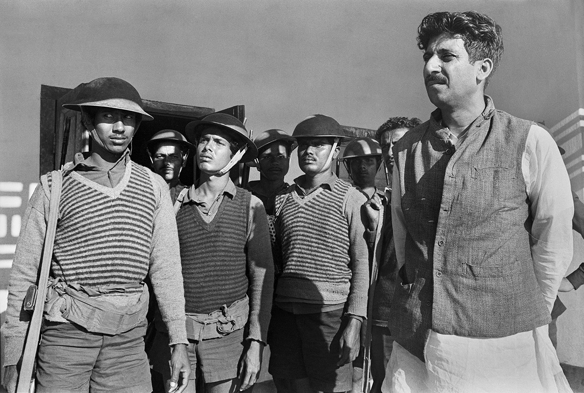Black and white photo of a group of soldiers with helmets wearing sweater vests