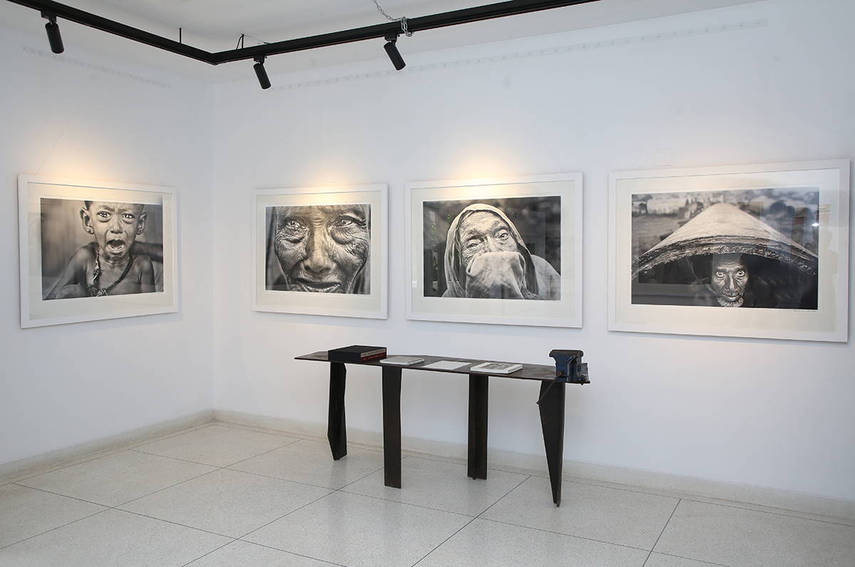 White gallery with black and white photos of people's distressed faces on the walls