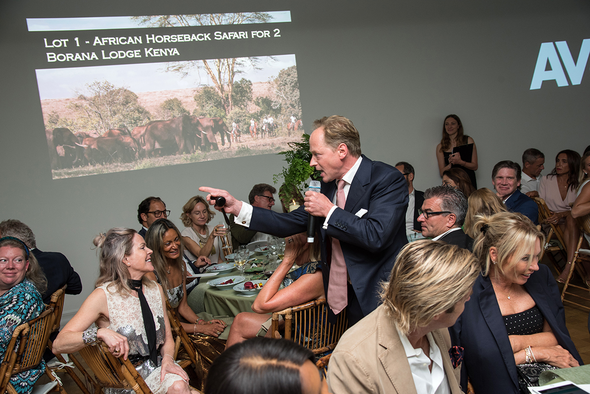 An auctioneer going round tables with a microphone