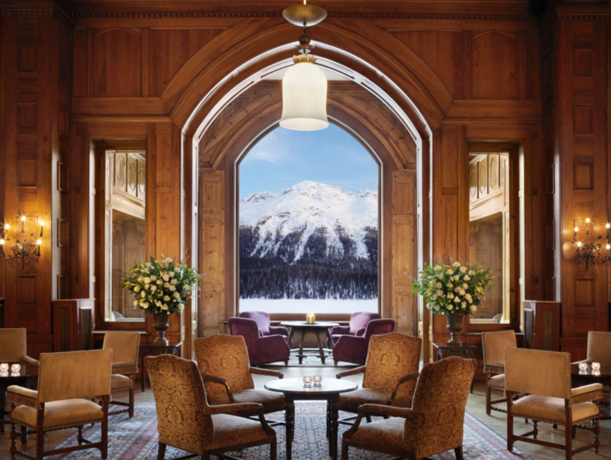 A lounge overlooking a large window with mountains covered in snow outside it