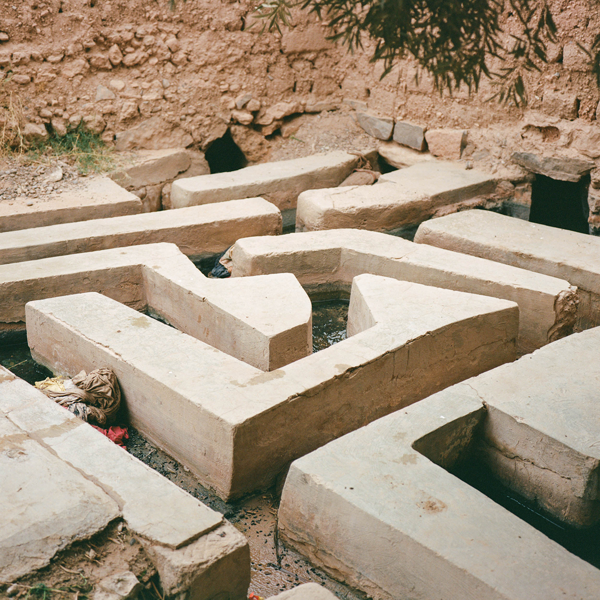 A mosaic of white stone walls in the sand cop