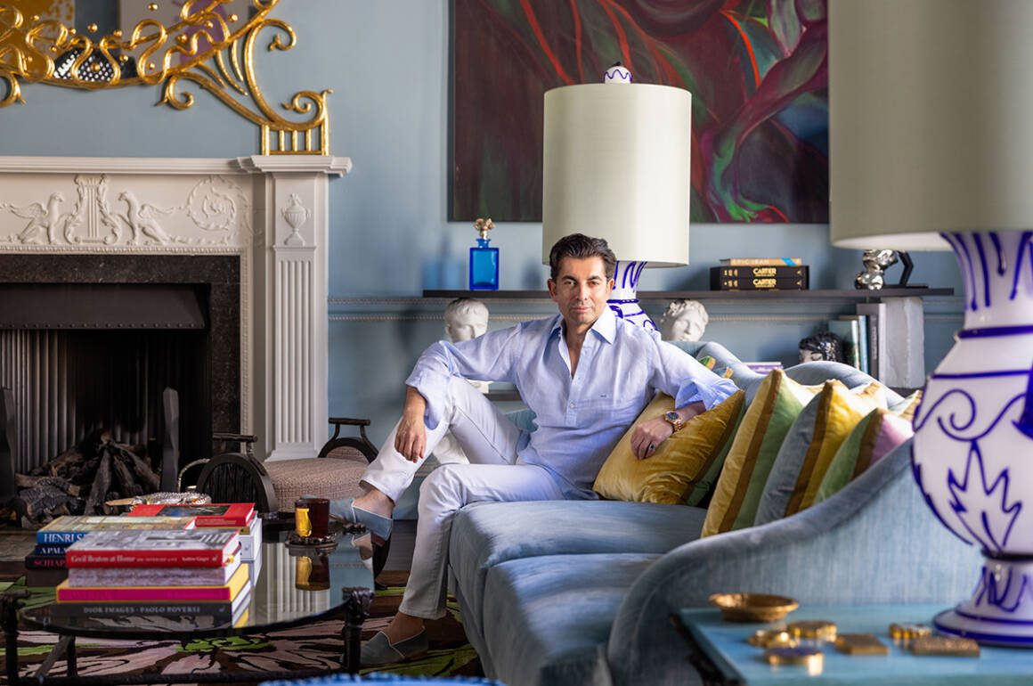 A man sitting on a blue couch with yellow cushions