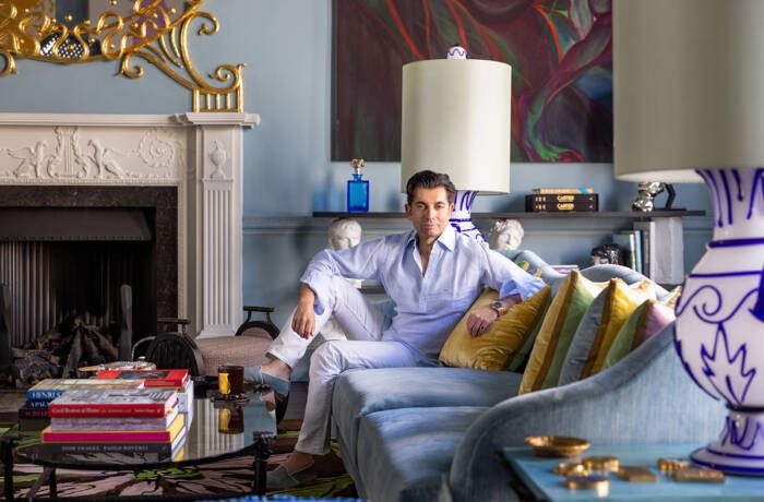 A man sitting on a blue couch with yellow cushions