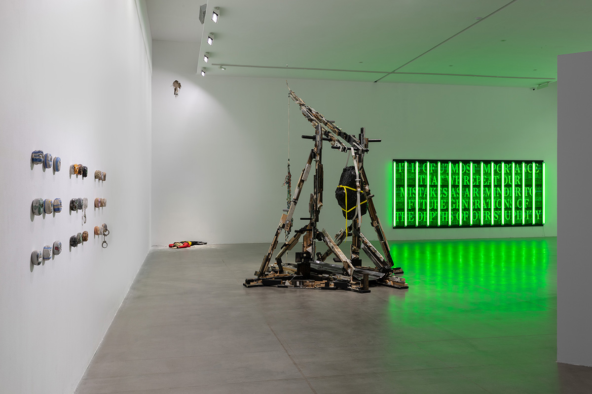 installations in a gallery including one with a bright green light