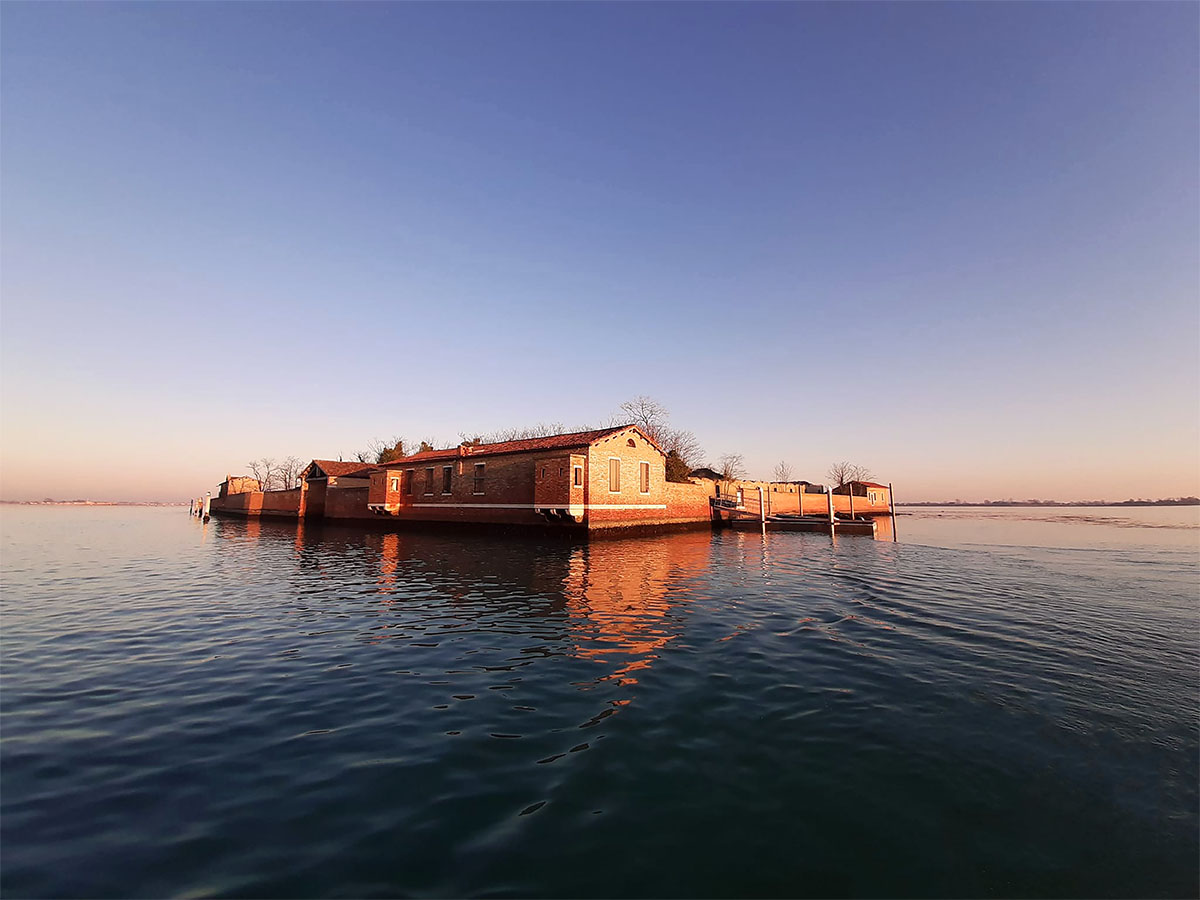 An island with a house on it in the middle of the sea