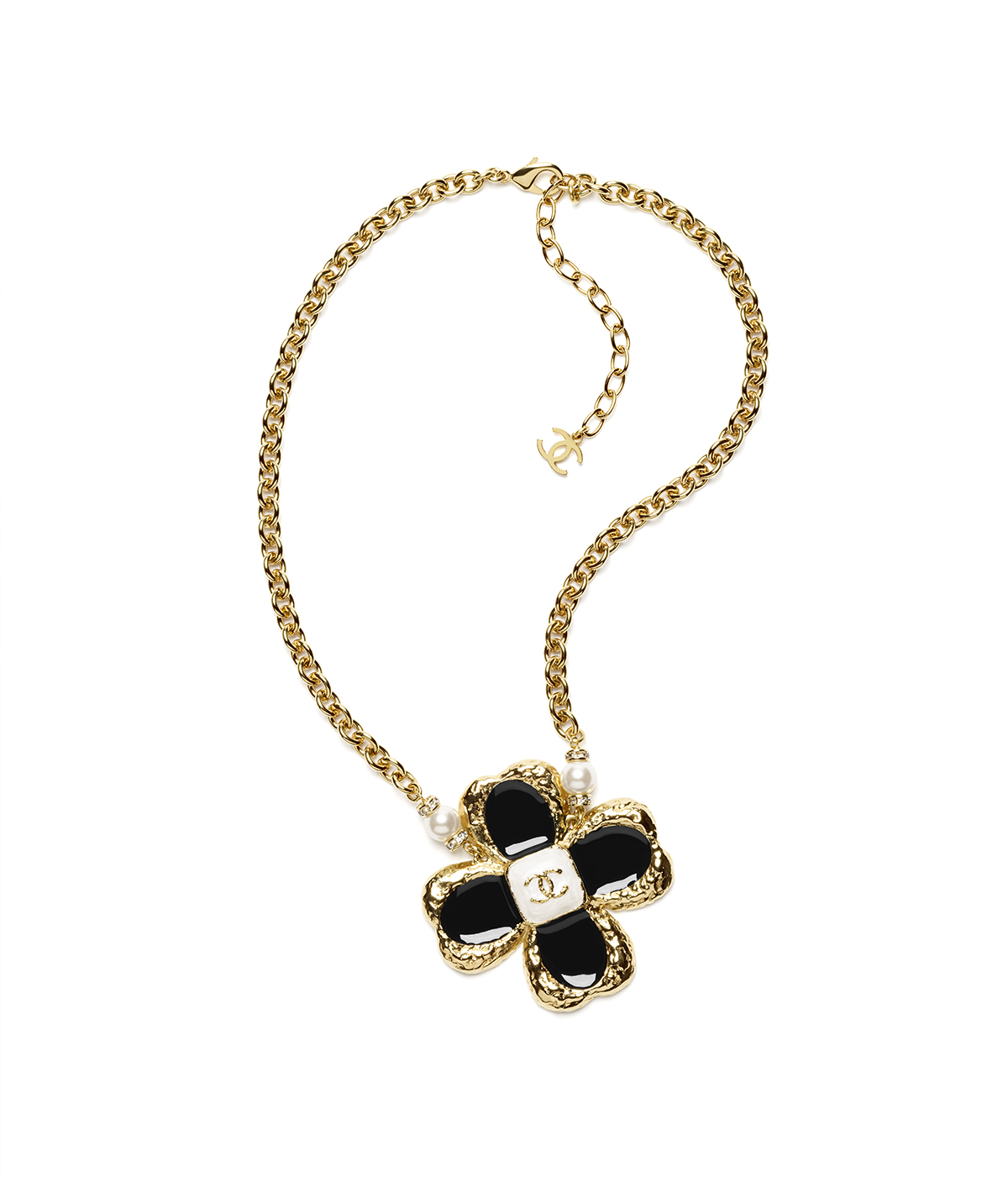 A gold necklace with a black flower and diamonds in the centre