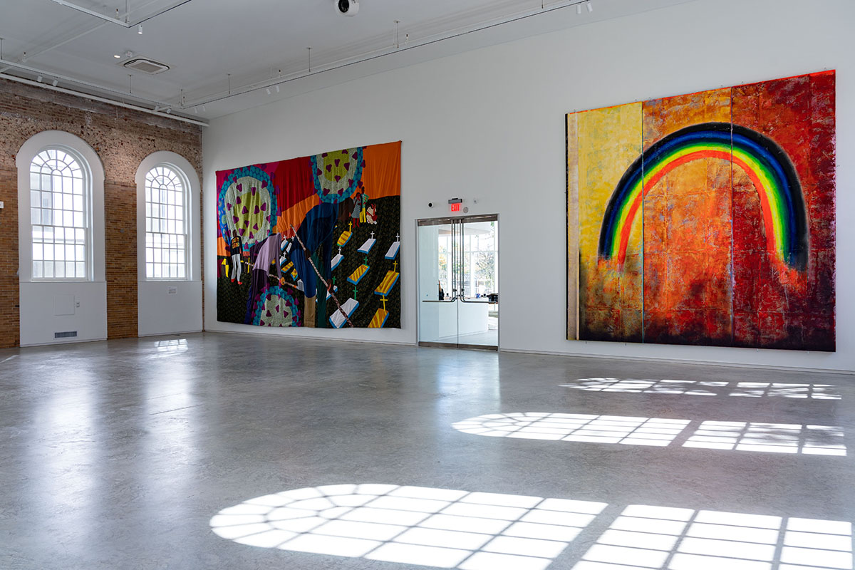 Colourful rainbow artworks in a gallery with light coming through the windows reflected on the ground