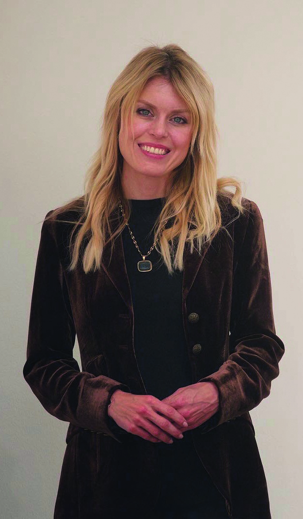 A blonde woman wearing a brown jacket