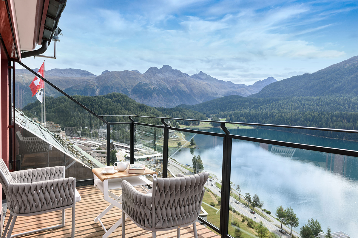 A terrace overlooking a lake and green mountains