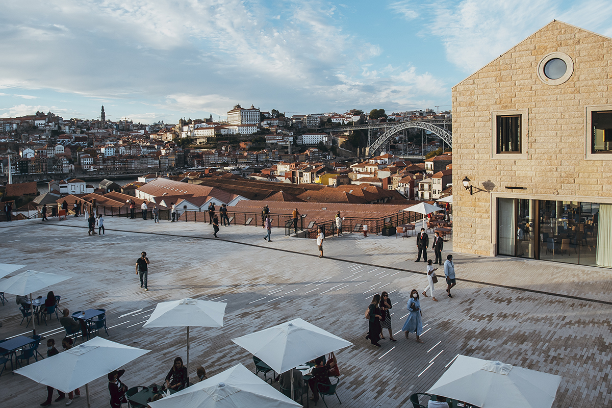 A pedestrian area with white parasols and a view of a city