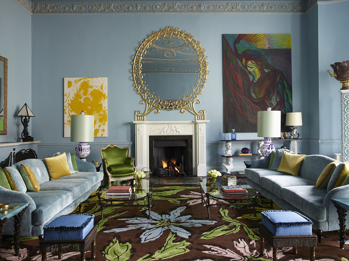 A colourful blue, green, brown and yellow room with a mirror over a fireplace