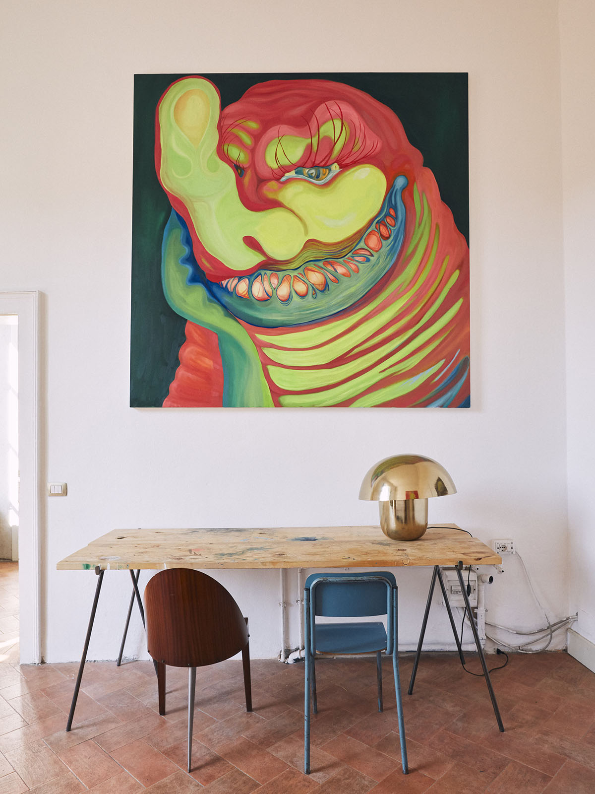 A painting of a green monster on top of a wooden table 