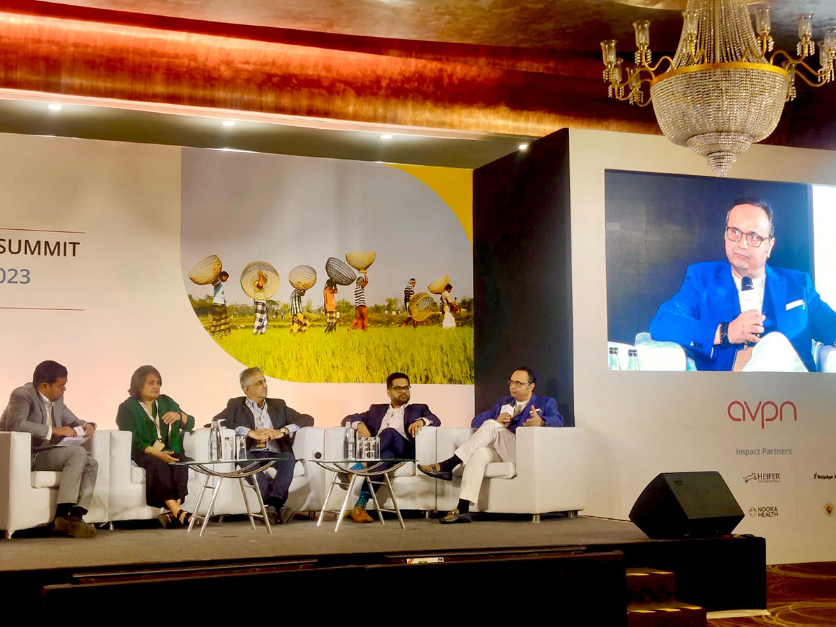 people sitting on chairs on a stage giving a panel discussion