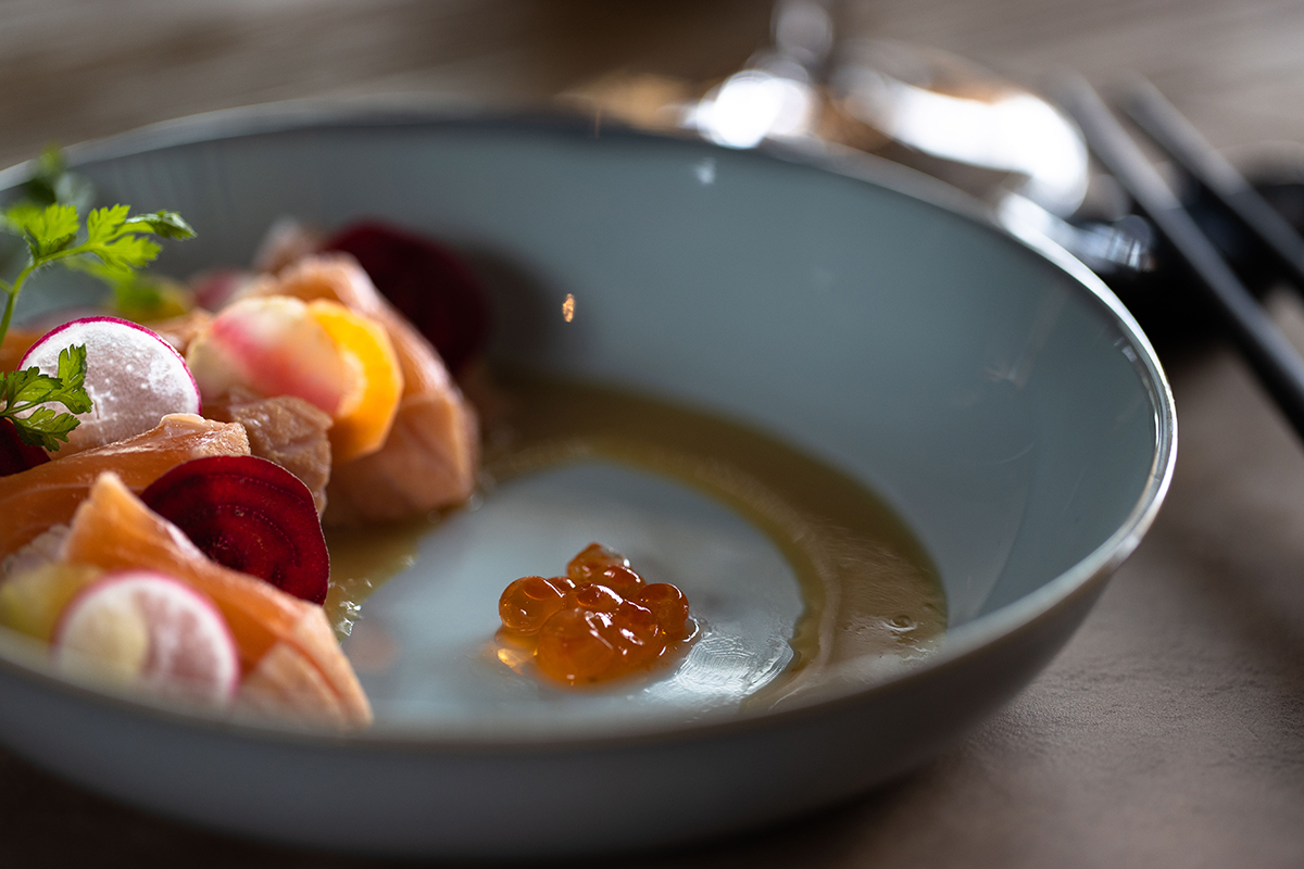 orange food on a grey plate with sauce