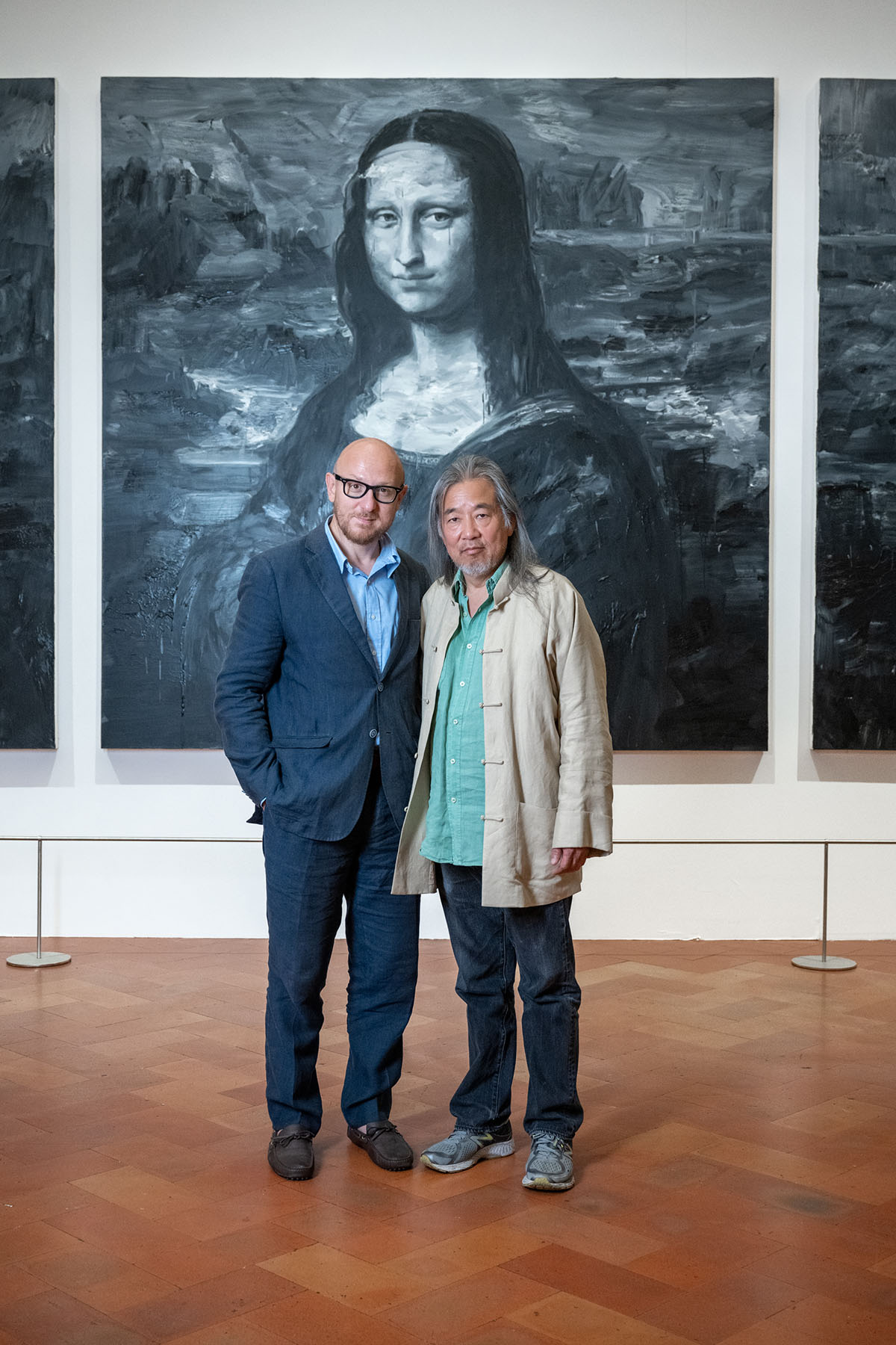 Two men standing in front of a painting of the Mona Lisa in blue