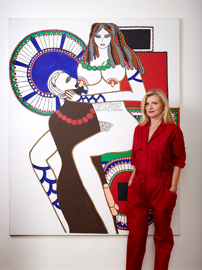 A woman wearing a red outfit standing next to an artwork of a woman 