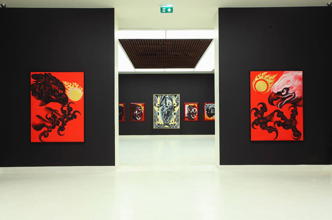 A galley with black walls and red paintings