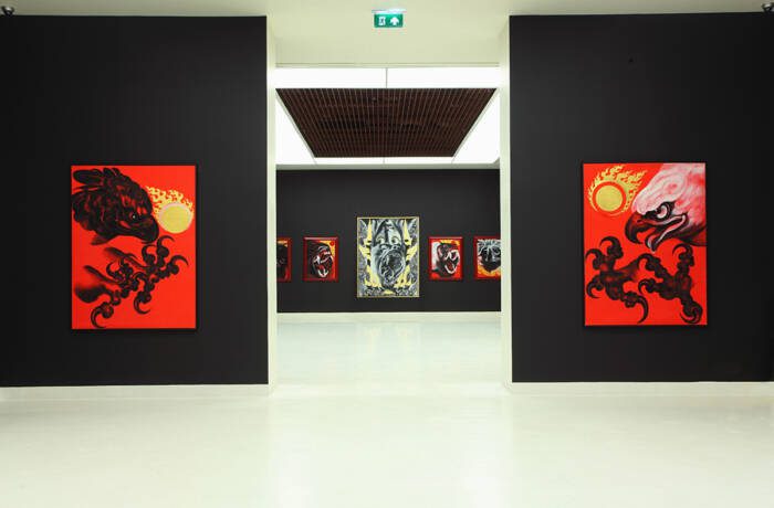 A galley with black walls and red paintings