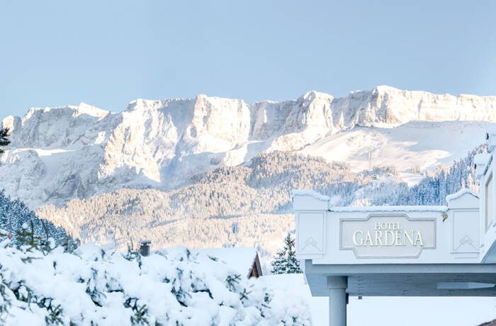 A sunny, snowy mountain top on the Alps with a Hotel view.