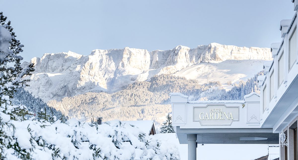 A sunny, snowy mountain top on the Alps with a Hotel view.