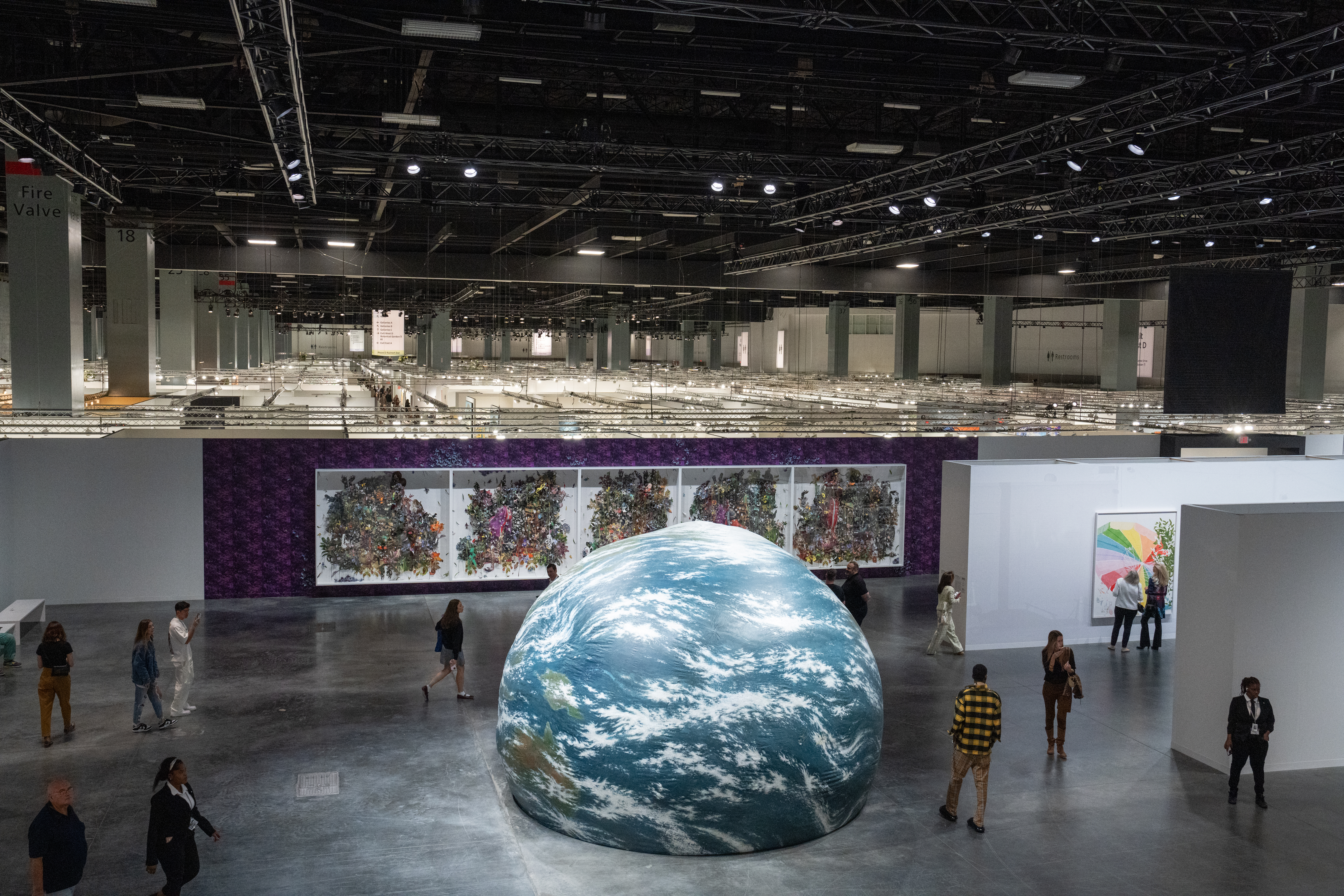 Large spherical sculpture of the earth at an art fair