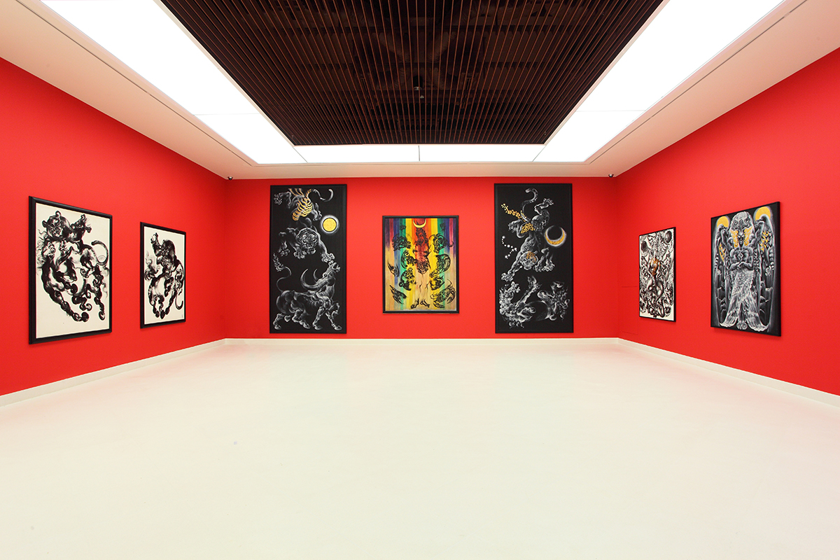 A museum with red walls and black and yellow paintings