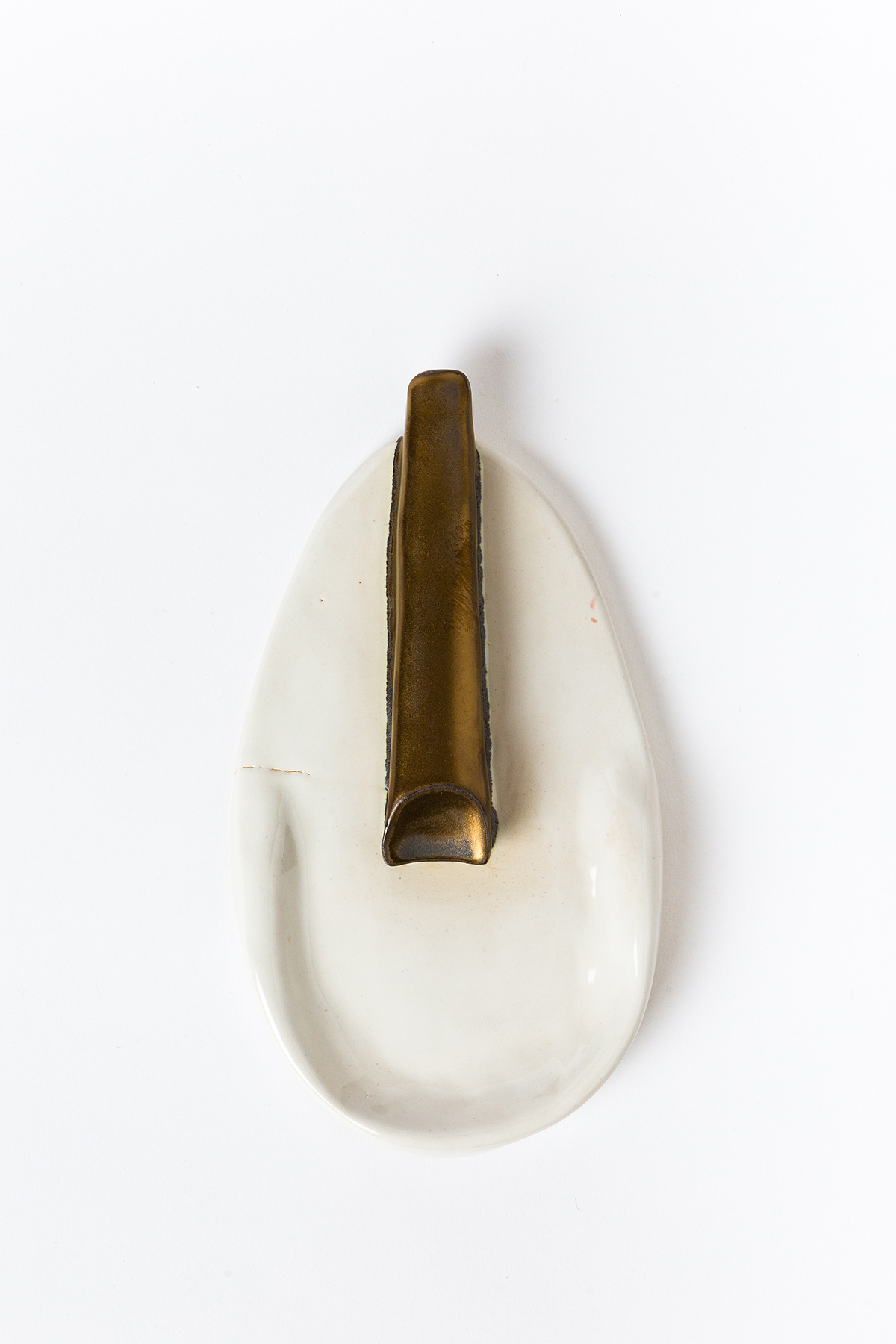 A white petal with a bronze stick in the middle of it
