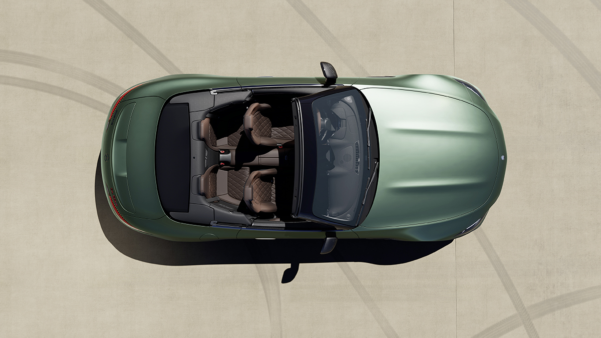 A green convertible car from above with brown leather seats