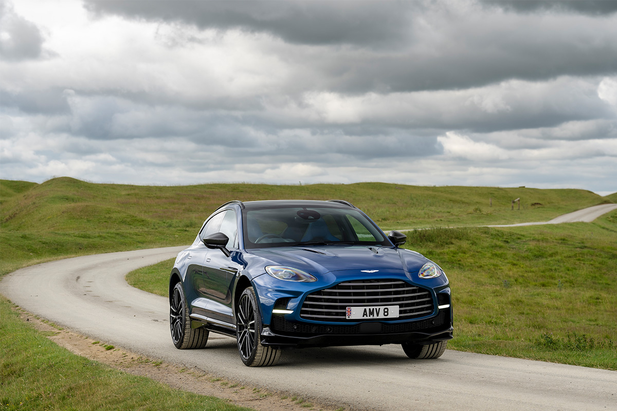 A blue SUV car driving on a road in the country side