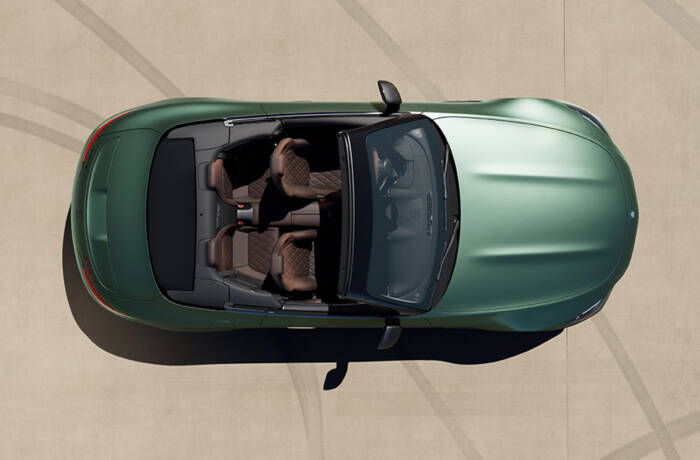 A green convertible car from above with brown leather seats
