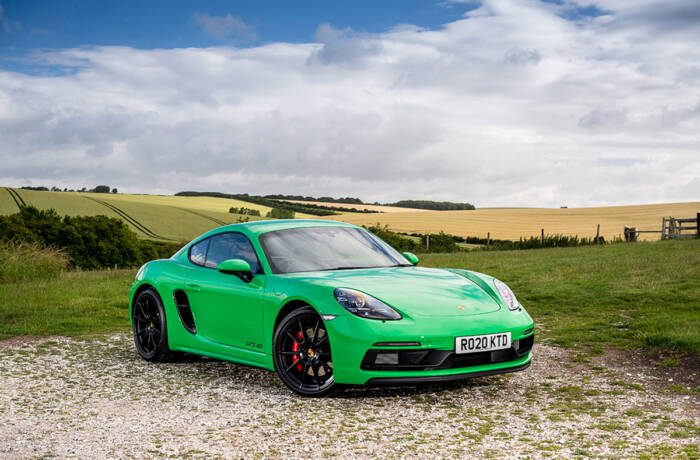 A green Porsche parked on a countryside road