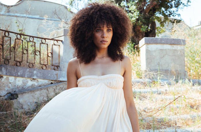 A woman wearing a white dress standing in a garden