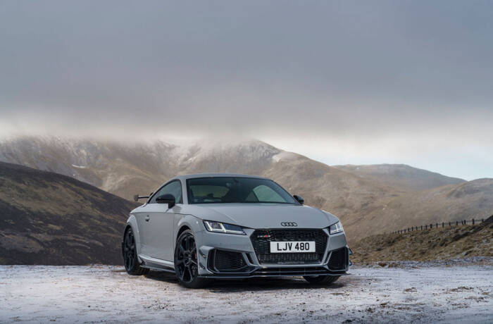 A grey car in the mountains with snow