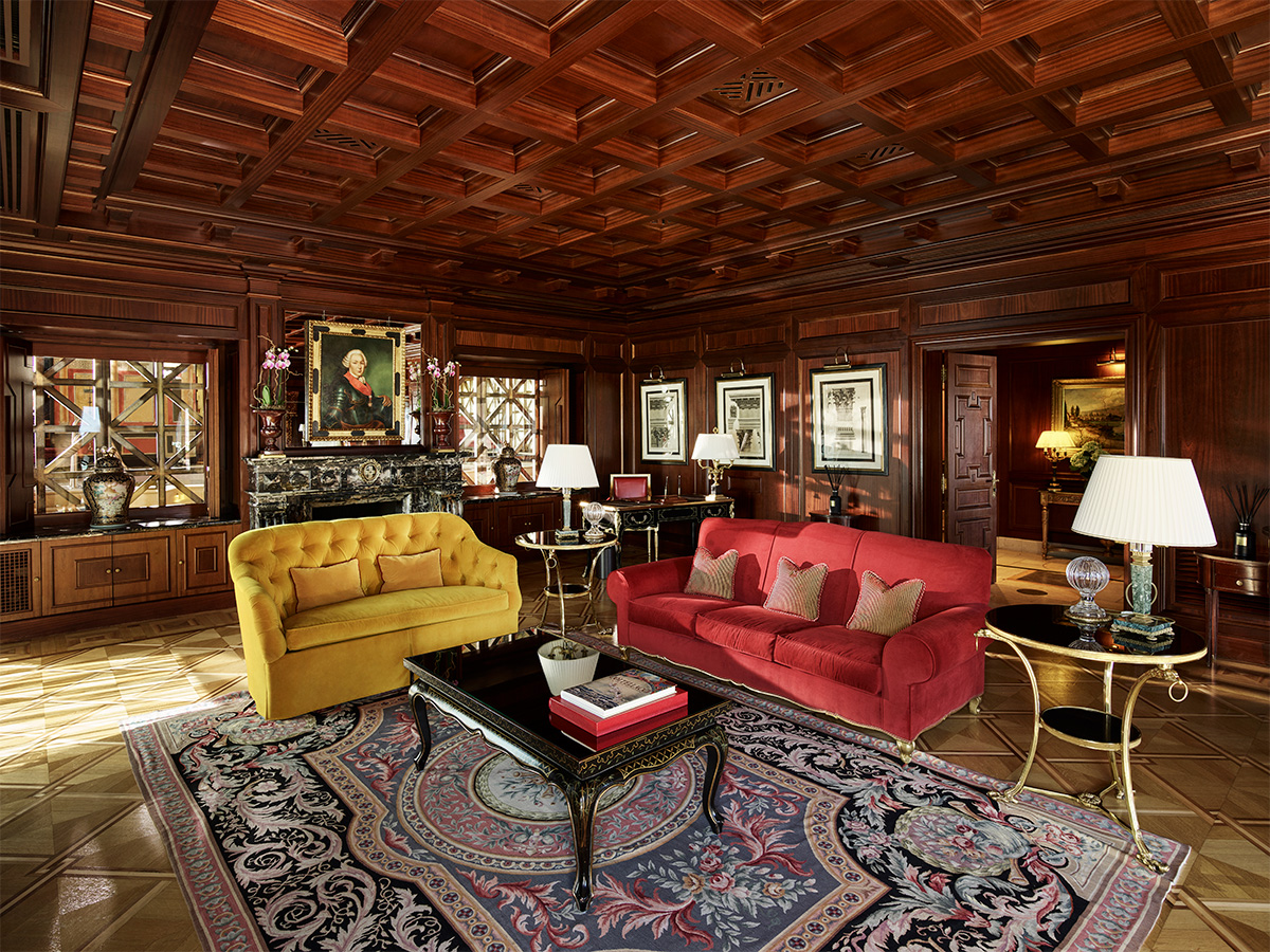 red and yellow sofas under wood ceiling in lavish, carpeted room