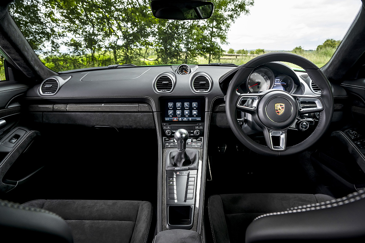 Black interiors of the gear shift and wheel inside a Porsche