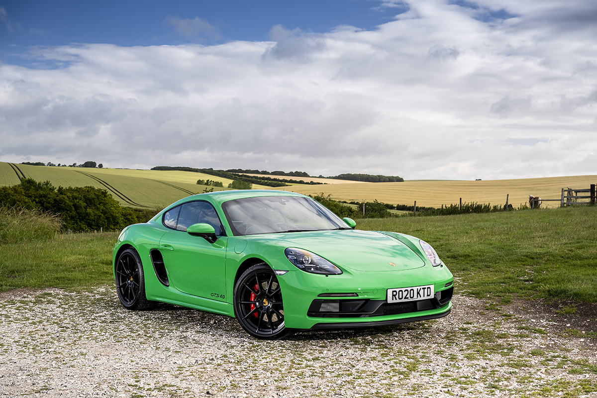 A green Porsche parked on a countryside road