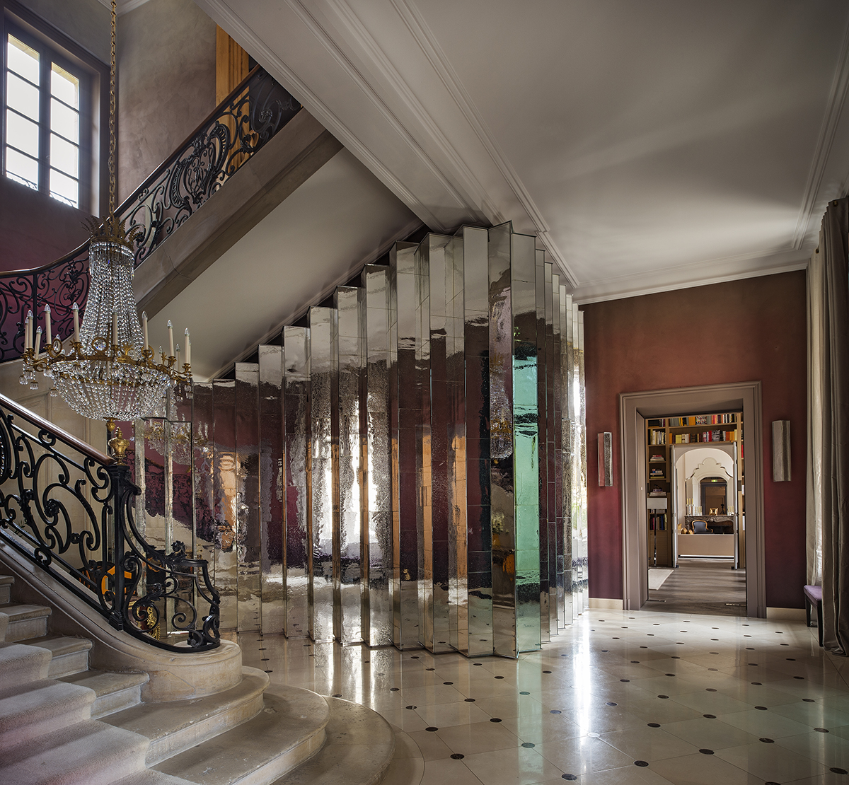 A hallway with a marble floor and staircase