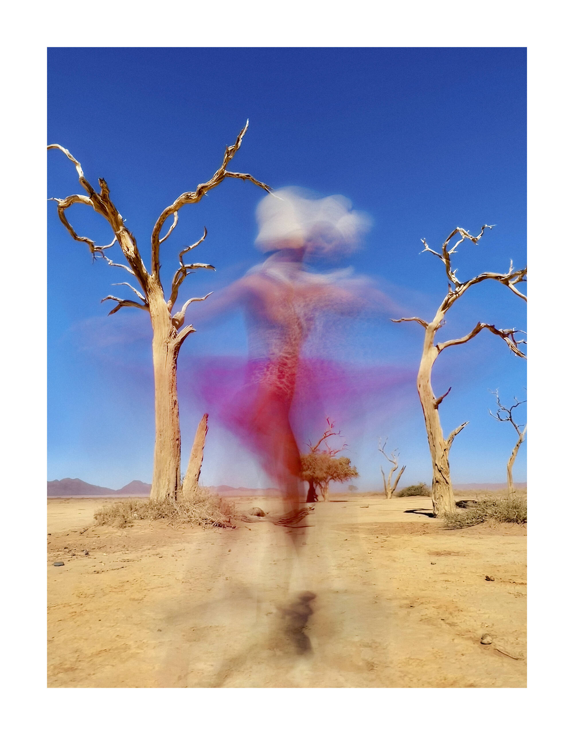 A woman in pink spinning against a bright blue sky with some trees