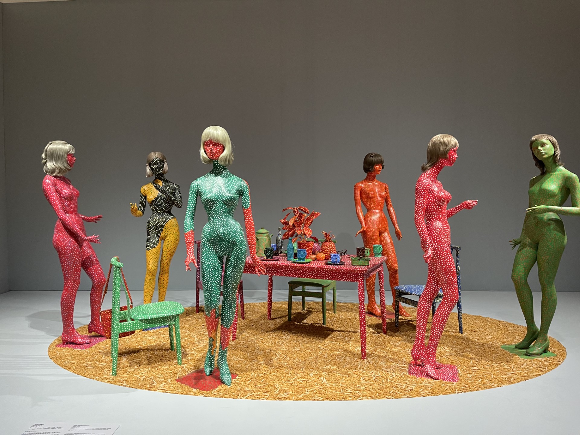 Colourful figures standing around a table