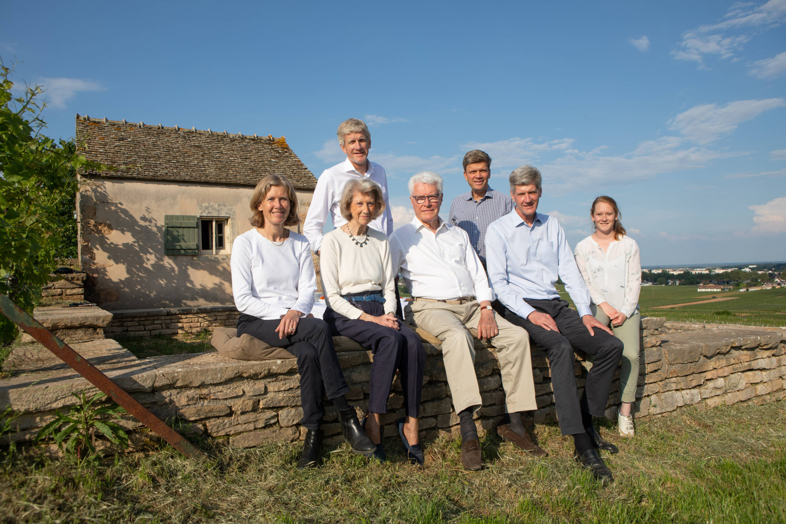 Family of different generations sitting on a stone wall