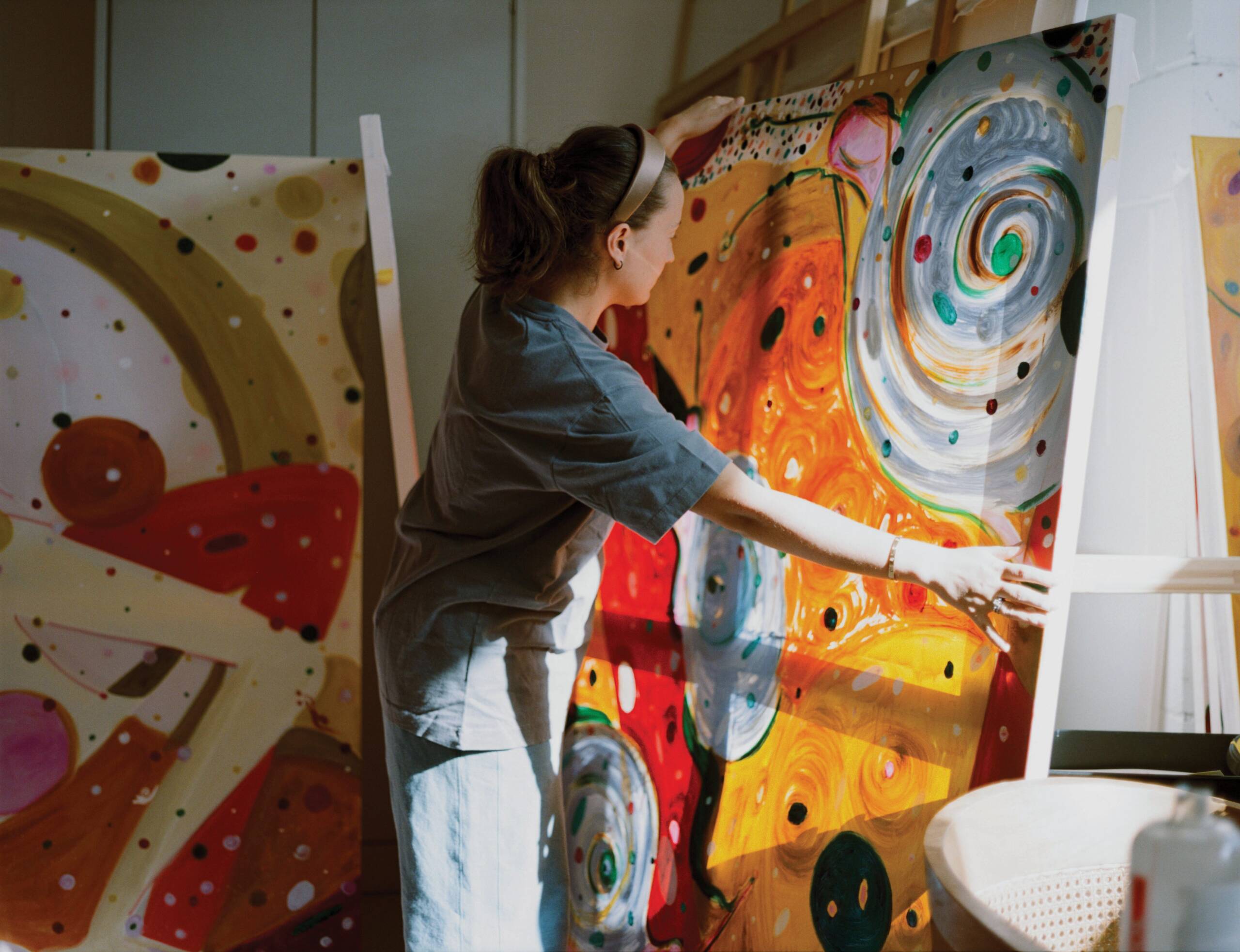 Woman that is painting, holding colourful painting up