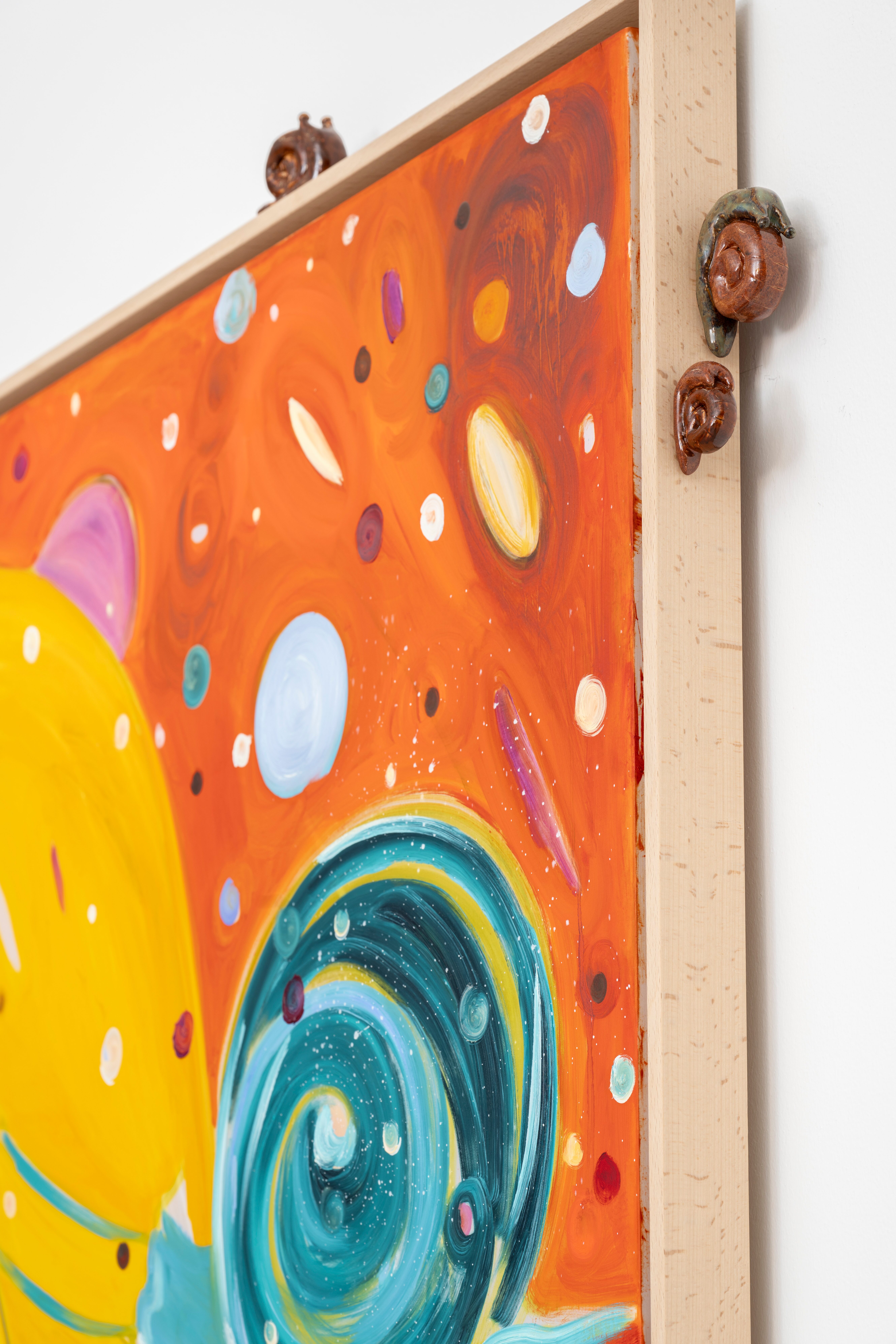 Little snails climbing on the side of a colourful painting.